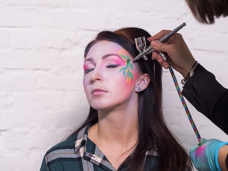 Airbrush artist finishing a full-body design before a New York City event